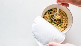 Persona che mangia noodles istantanei riscaldati