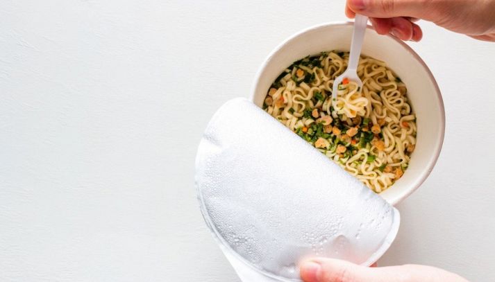 Persona che mangia noodles istantanei riscaldati