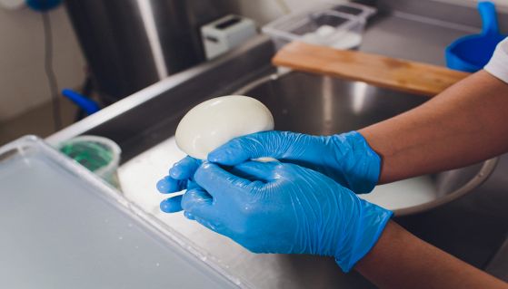 Operaio impegnato nella produzione della mozzarella