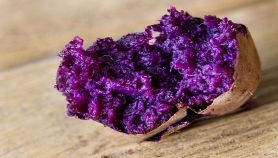 Patata viola arrosto su tavolo di legno