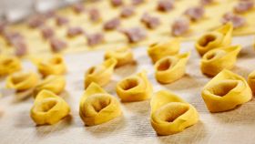Produzione artigianale dei tortellini all'interno di un pastificio