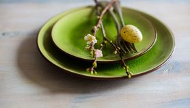 Un ramo di ciliegio in fiore come decorazione ornamentale su un piatto verde con uovo di quaglia
