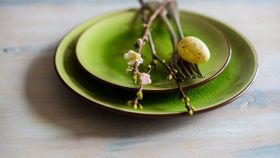 Un ramo di ciliegio in fiore come decorazione ornamentale su un piatto verde con uovo di quaglia