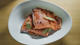 Salmone con alloro e pepe su piatto bianco