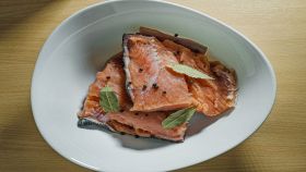 Salmone con alloro e pepe su piatto bianco