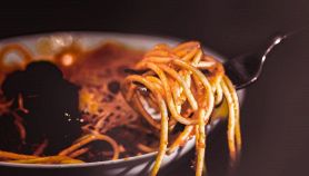 Piatto di spaghetti con salsa e una forchettata pronta da mangiare