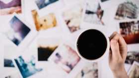 Una mano sorregge una tazza di caffè fumante