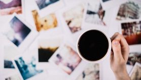 Una mano sorregge una tazza di caffè fumante