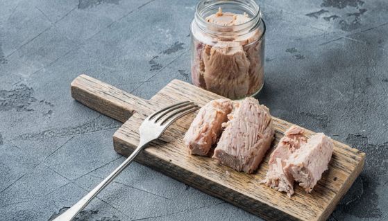 Tranci di tonno all'olio d'oliva in barattolo e su tagliere