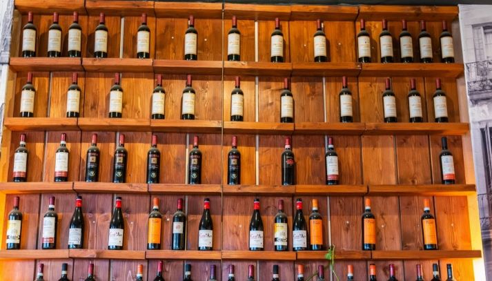 Bottiglie di vino di differenti etichette in esposizione in enoteca