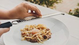 Chef donna grattugia il parmigiano sulla carbonara