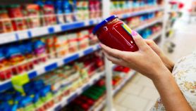 Donna al supermercato che sceglie passata di pomodoro