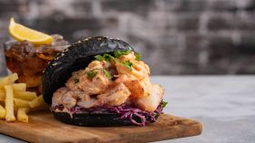 Hamburger nero con pesce e gamberi e patatine fritte