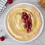 Piatto con hummus con ciliegie arrostite