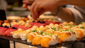 Maki sushi roll diversi su vassoio nero