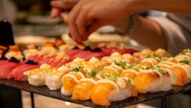 Maki sushi roll diversi su vassoio nero