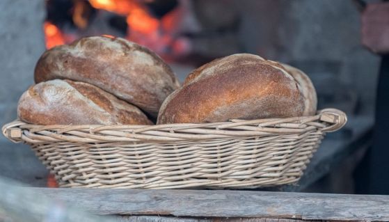 Tre pagnotte cotte in forno a legna e poste in un cestino