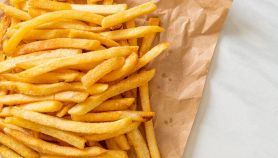 Porzione di patatine fritte salate su carta assorbente