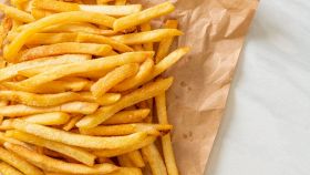 Porzione di patatine fritte salate su carta assorbente