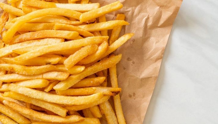 Porzione di patatine fritte salate su carta assorbente