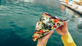 Spicchio di pizza farcita con mare sullo sfondo