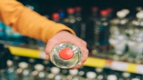 Uomo con bottiglia d'acqua al supermercato