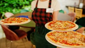 Cameriera del ristorante che porta le pizze