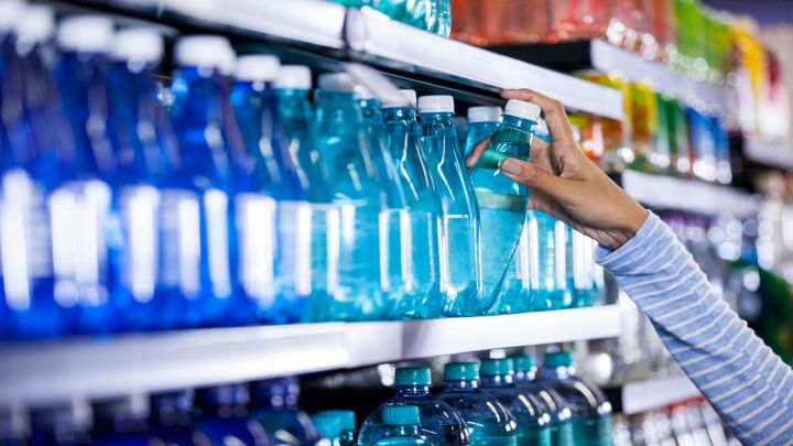 Mani femminili acquistano bottiglia d'acqua