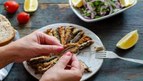 Alici fritte impiattate e mangiate da una donna