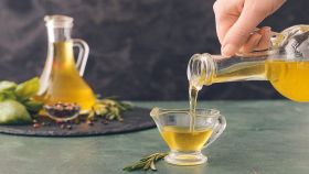Mani femminili versano olio d'oliva