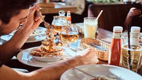 Tavolo di amici al ristorante con ragazzo in primo piano