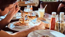Tavolo di amici al ristorante con ragazzo in primo piano