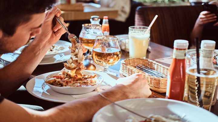 Tavolo di amici al ristorante con ragazzo in primo piano
