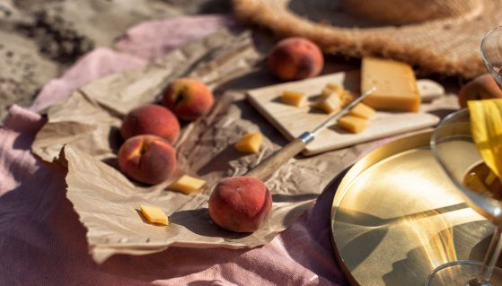 Telo in spiaggia con pesche e formaggio stagionato