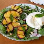 Piatto di pesche grigliate con burrata e menta