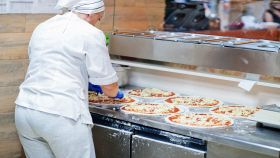 Pizzeria con chef che fa le pizze