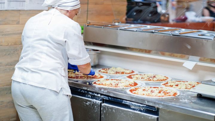 Pizzeria con chef che fa le pizze