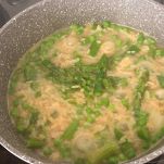 Risotto asparagi e piselli che cuoce in pentola