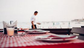 Ristorante con tavolo apparecchiato vista mare