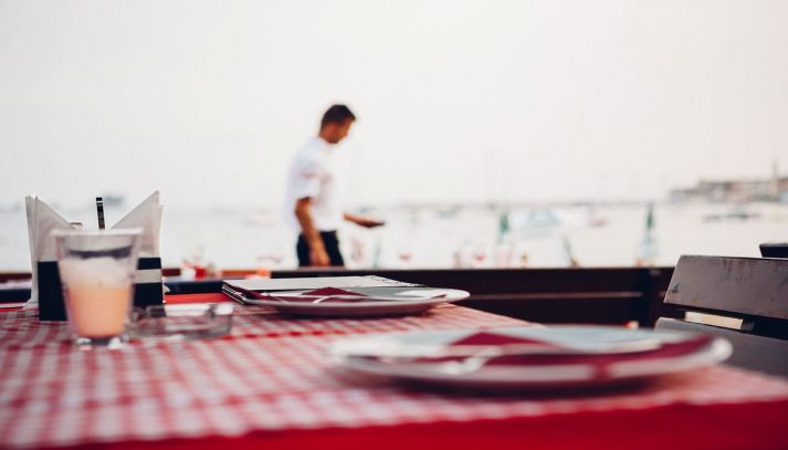 Ristorante con tavolo apparecchiato vista mare