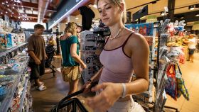 Una turista con un carello portatile fa spesa in un supermarket