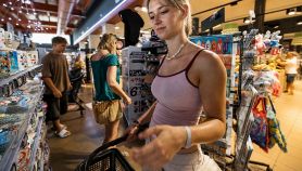 Una turista con un carello portatile fa spesa in un supermarket