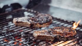 Barbecue con bistecche in cottura