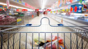 Carrello con corsia del supermercato sullo sfondo