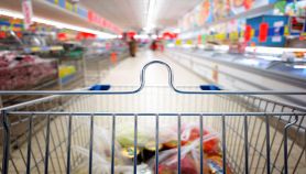 Carrello con corsia del supermercato sullo sfondo