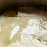 Sfoglie di pasta cuociono nell'acqua bollente