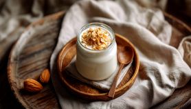 Crema di mandorle nel vasetto con piatto e cucchiaio di legno