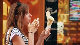 Donna mangia gelato fuori dalla gelateria