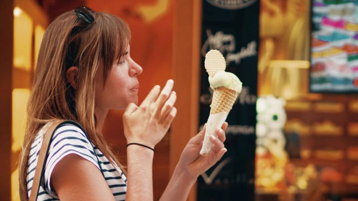 Donna mangia gelato fuori dalla gelateria