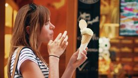 Donna mangia gelato fuori dalla gelateria